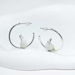 Hoop earrings with bird charms on a white background
