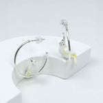 Silver-plated hoop earrings with white enamel cockatoo bird accents, a whimsical and chic statement for everyday wear