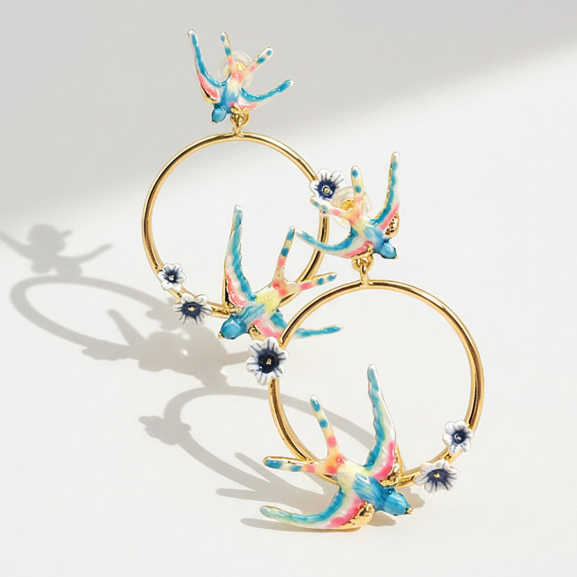 Colorful hoop earrings with floral designs on a light gray background