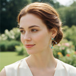 Woman wearing earrings with a blurred garden background