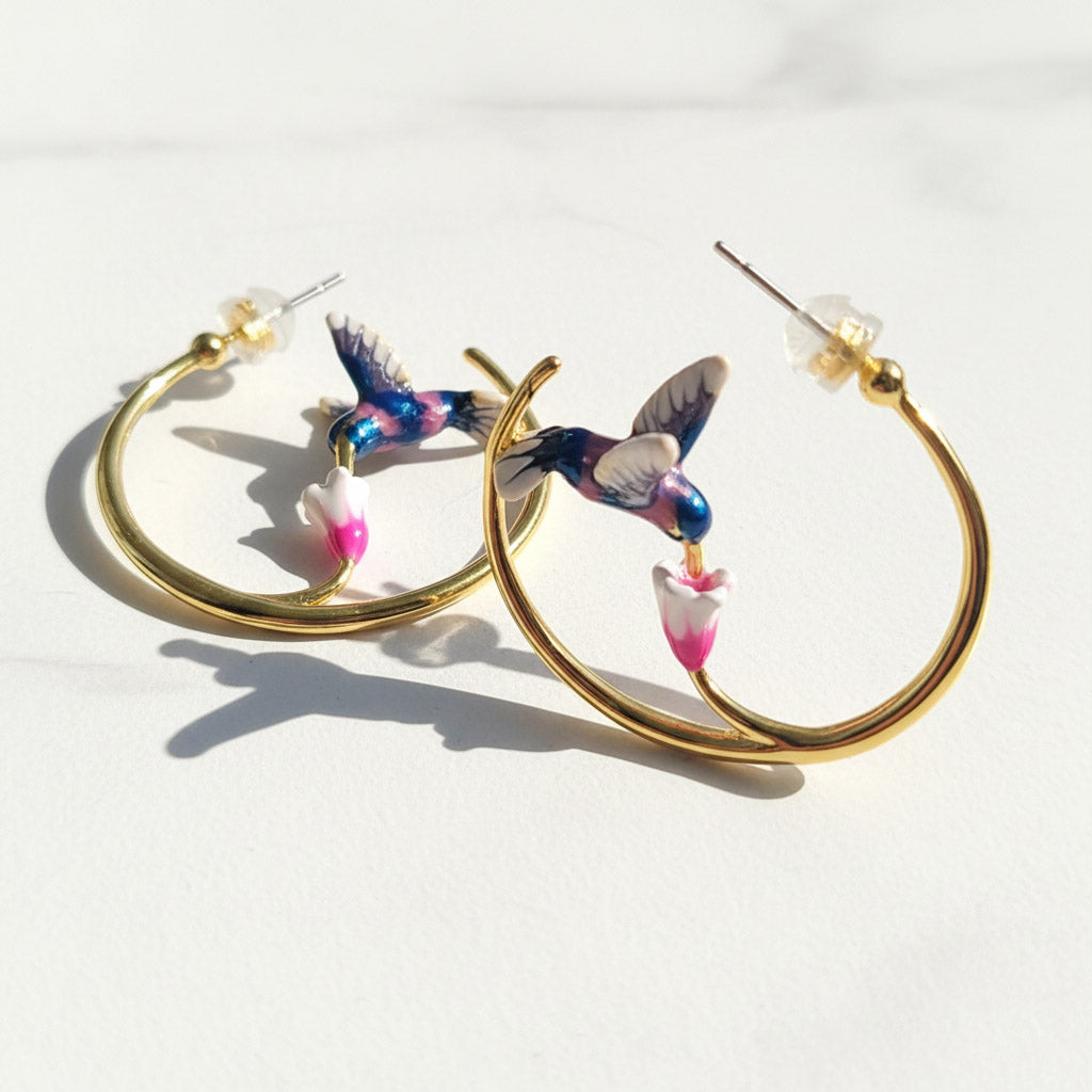 Hoop earrings with hummingbird designs on a white background