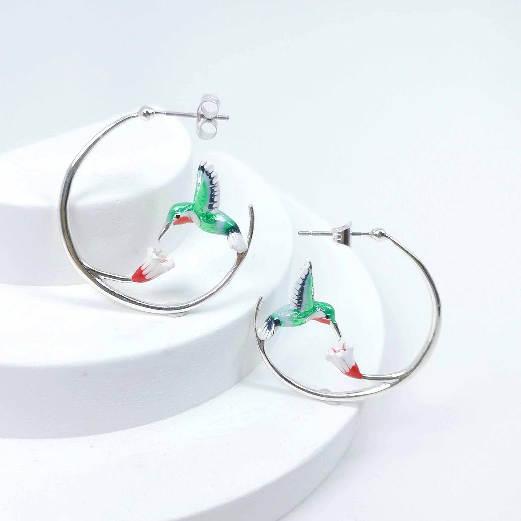 Hoop earrings with hummingbird design on a white background