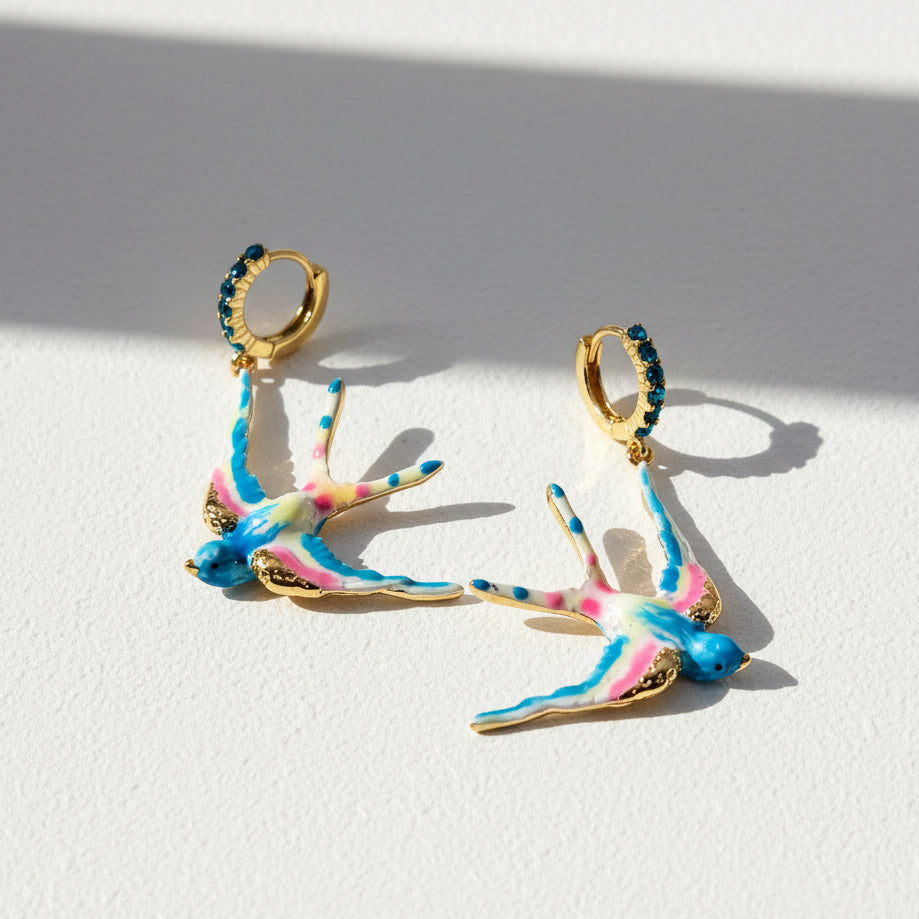 Colorful bird-shaped earrings on a white background