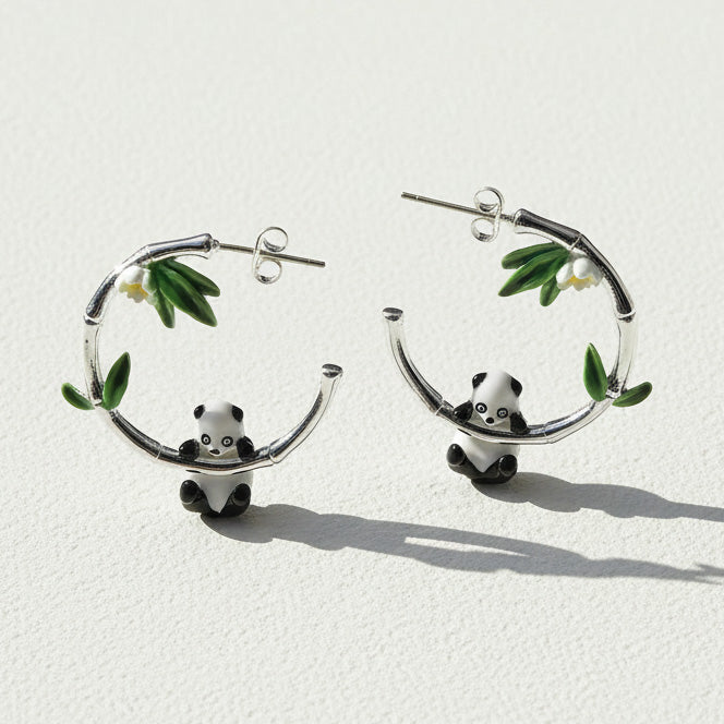 Panda bear earrings with bamboo leaves on a white background