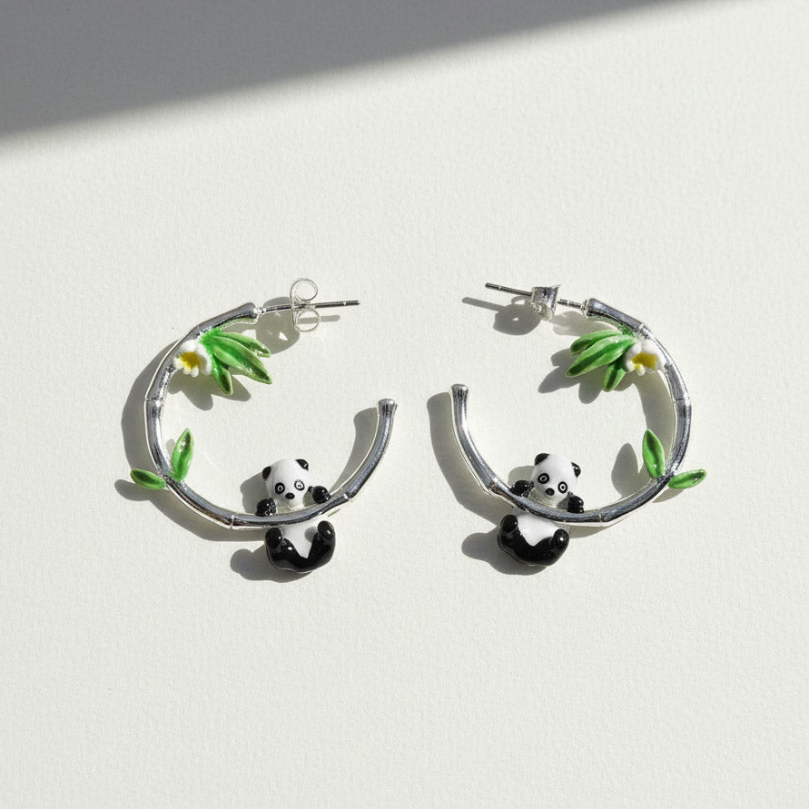 Hoop earrings with panda designs on a white background
