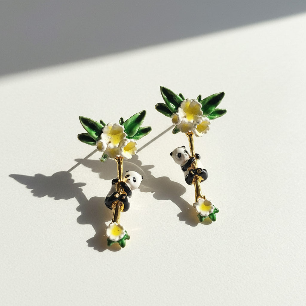 Pair of earrings with panda bears and flowers on a white background