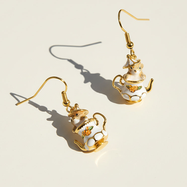 Teapot-shaped earrings with gold accents on a light background