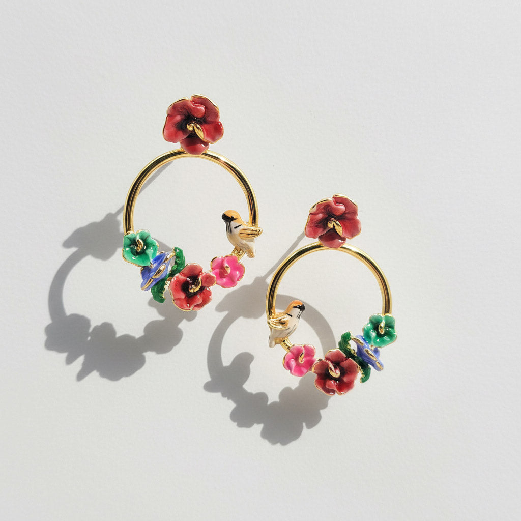 Colorful floral hoop earrings on a light gray background