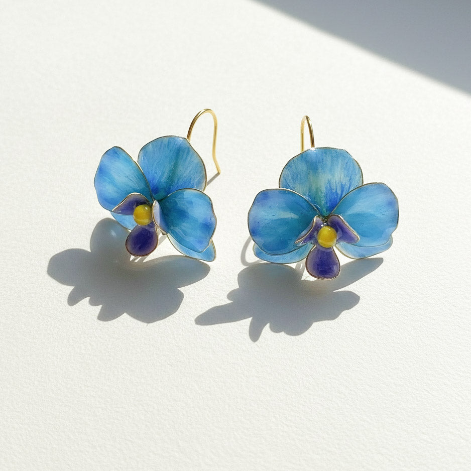 Blue flower-shaped earrings on a white background