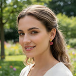 Woman wearing colorful earrings in a garden setting