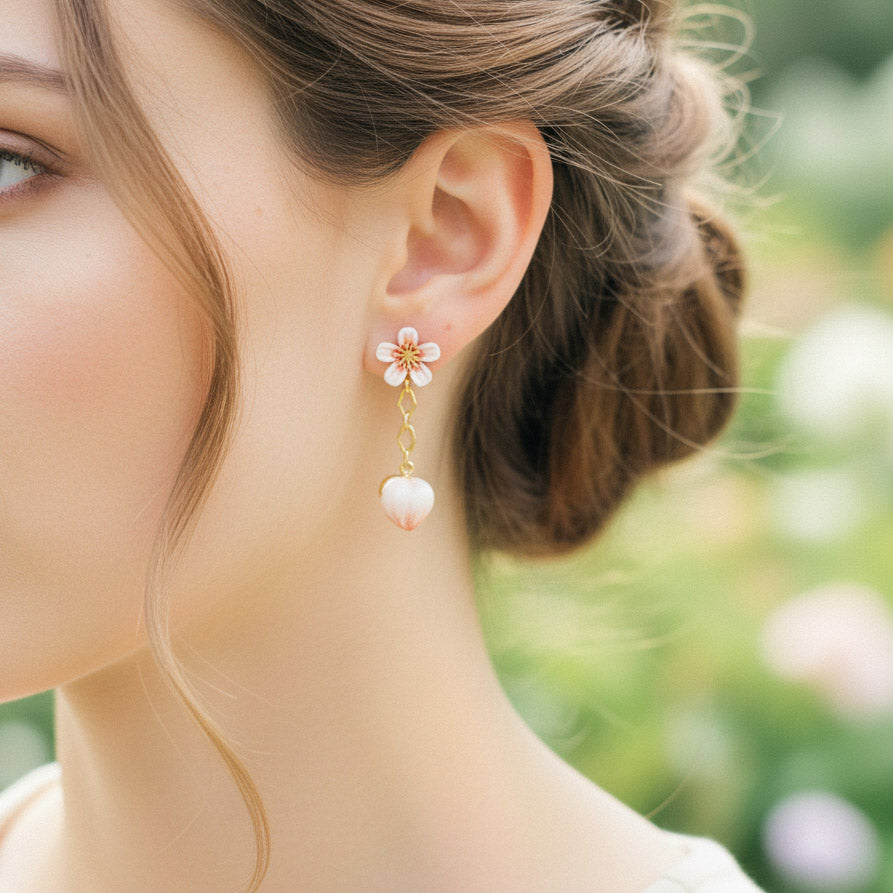 Close-up of a woman wearing a floral earring with a blurred natural background
