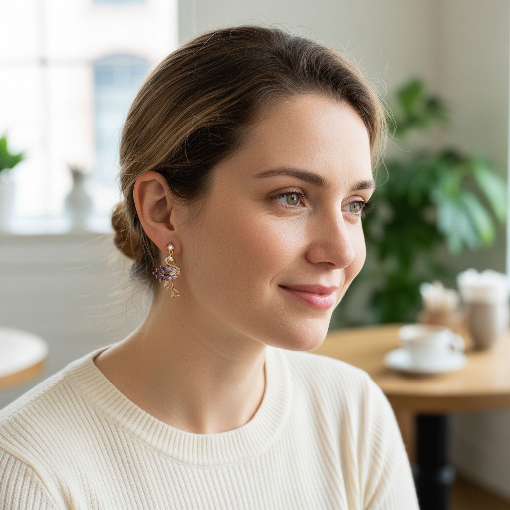 Model wearing gold flamingo crystal drop earrings with purple stones