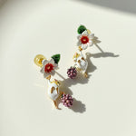 Decorative earrings with floral and animal designs on a light background