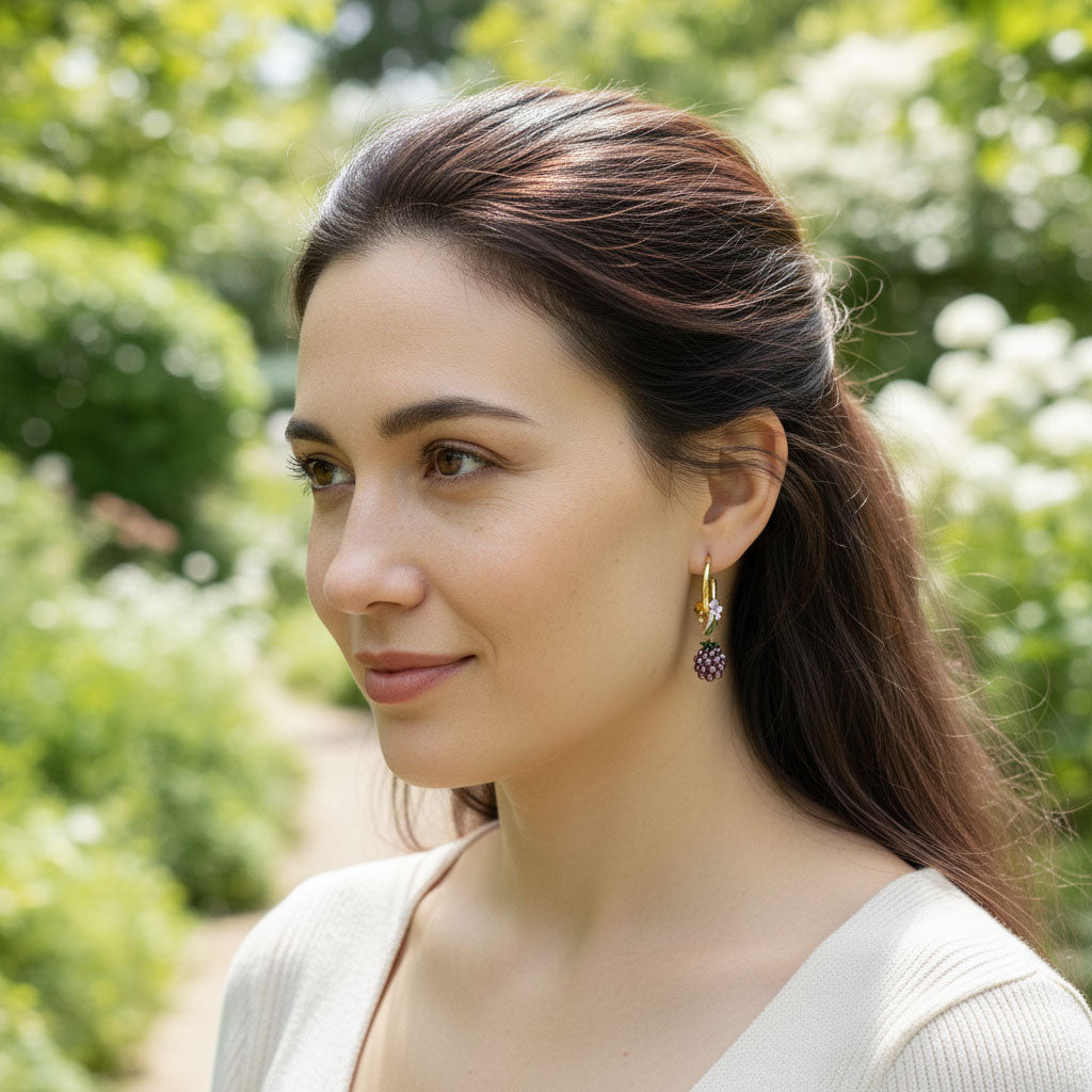 Woman with long brown hair wearing earrings in a garden setting
