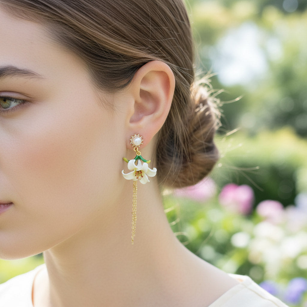 Close-up of a woman wearing floral earrings with a blurred garden background