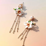 Floral earrings with gold chains on a soft background