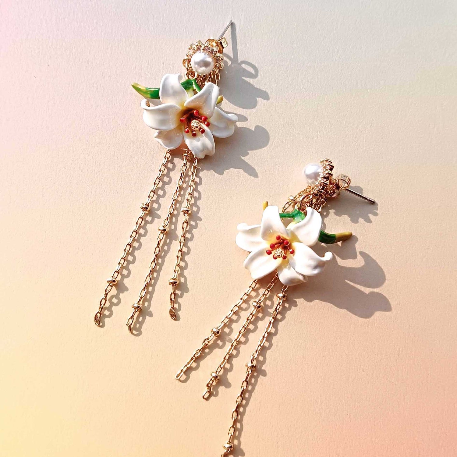 Floral earrings with gold chains on a soft background