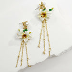 Floral earrings with gold chains on a light background
