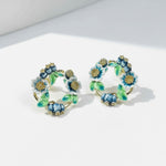 Floral hoop earrings with blue and green flowers on a white background