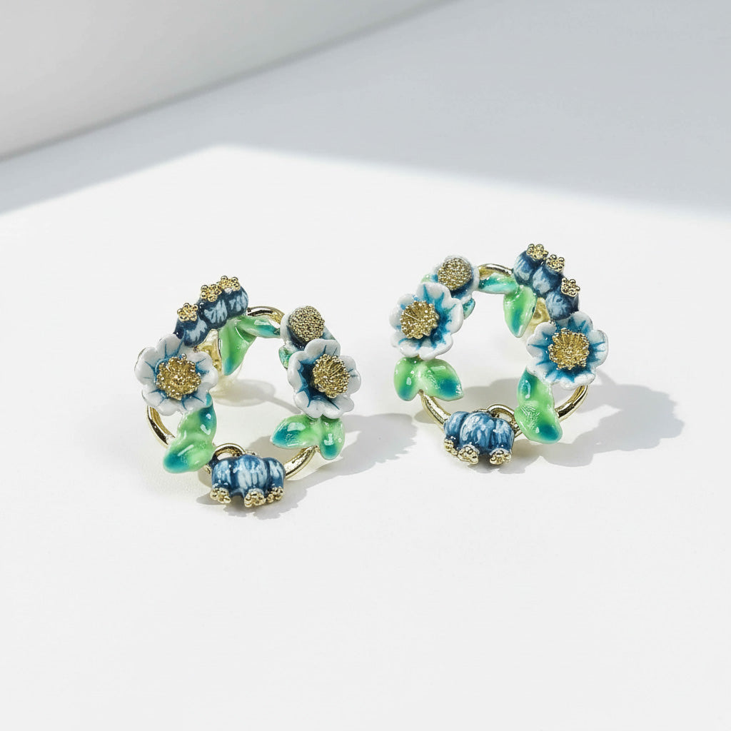 Floral hoop earrings with blue and green flowers on a white background