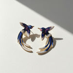 Pair of bird-shaped earrings on a light background