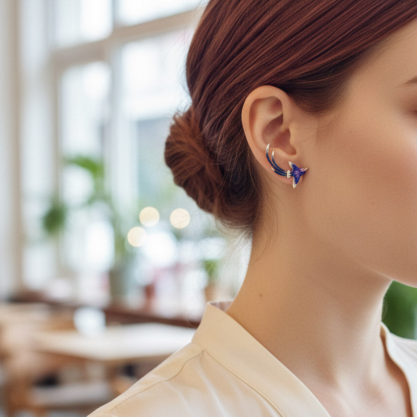 Close-up of a person wearing a floral earring with a blurred indoor background