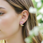 Close-up of a woman wearing a floral earring with a blurred natural background