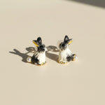 Pair of dog-shaped earrings on a beige background