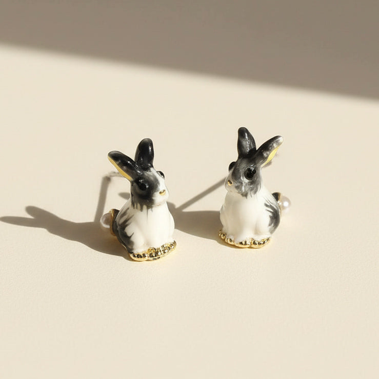 Pair of rabbit-shaped earrings on a beige background