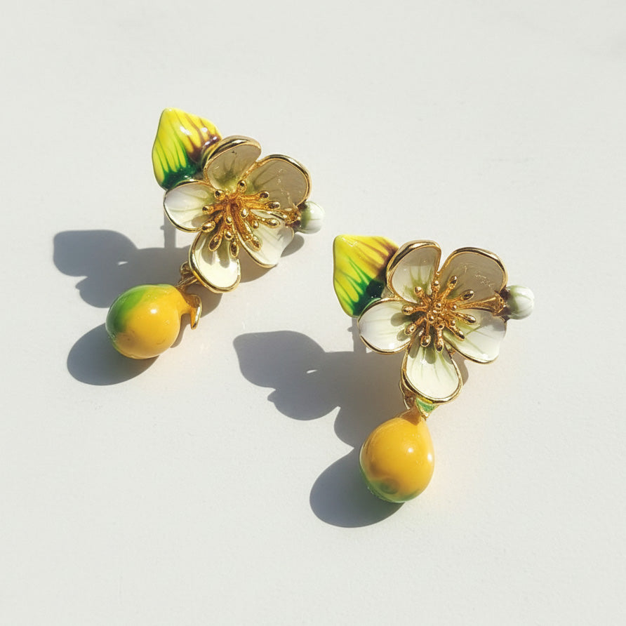 Floral earrings with yellow and green accents on a light background