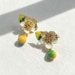 Floral earrings with green and yellow accents on a white background