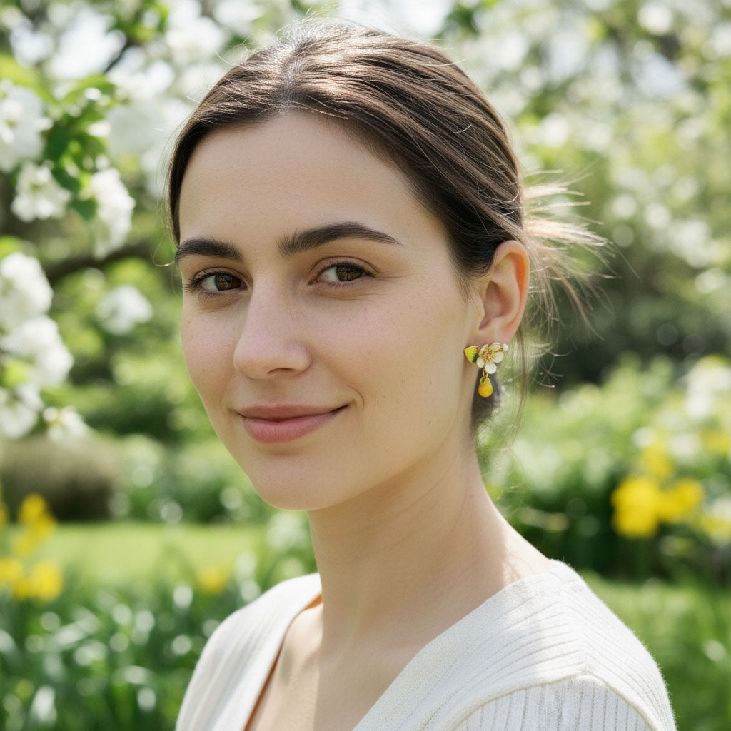 Woman with earrings standing in a garden with flowers and greenery