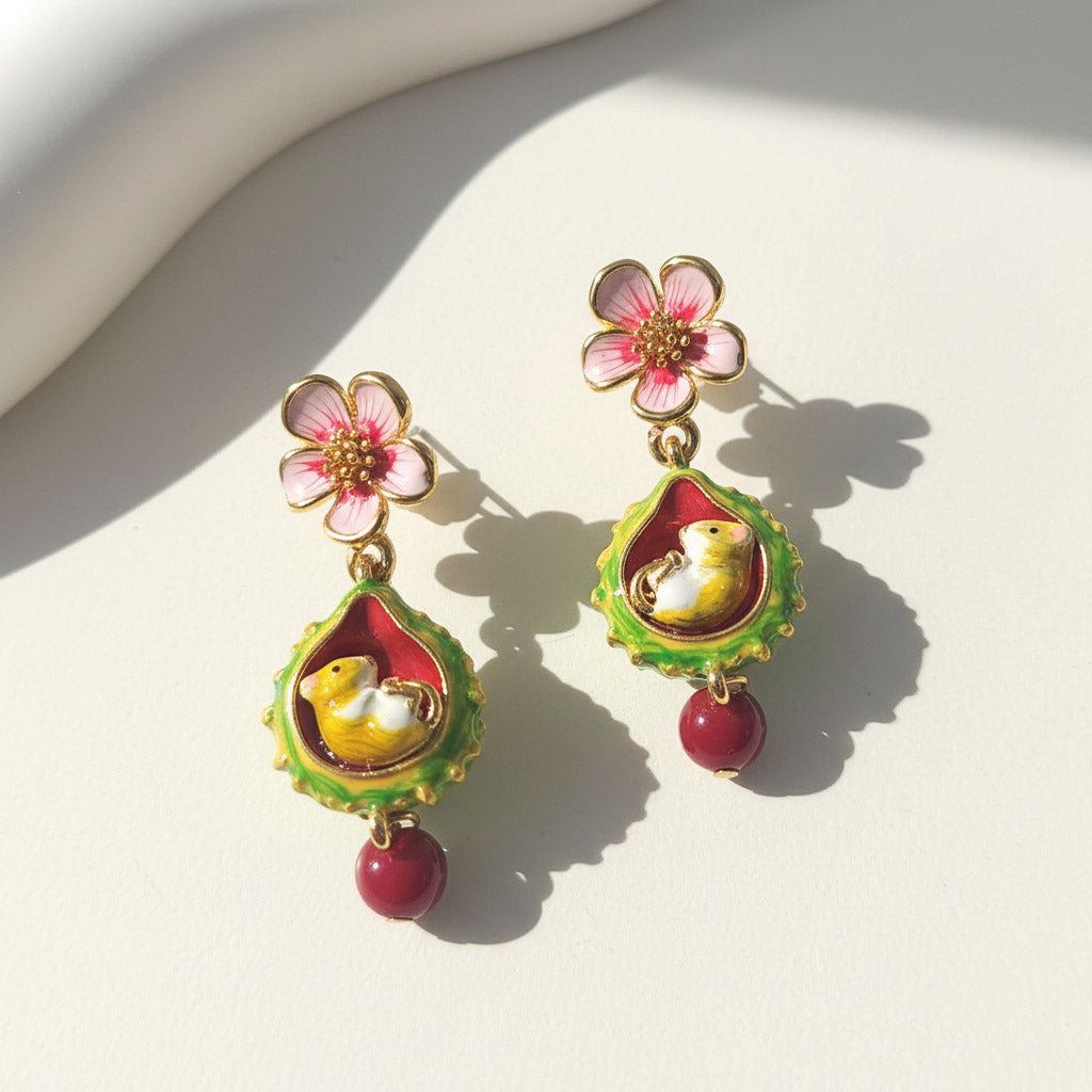 Pair of floral earrings with mouse design on a light background