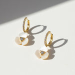 Side view of gold floral hoop earrings with CZ stones