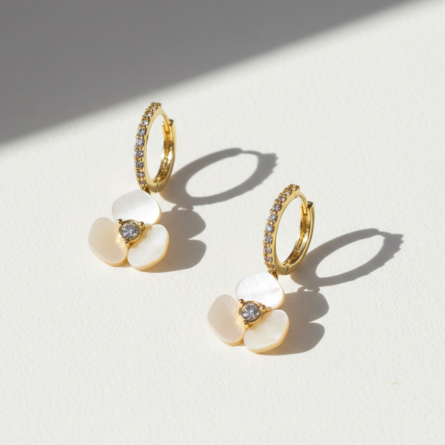 Side view of gold floral hoop earrings with CZ stones