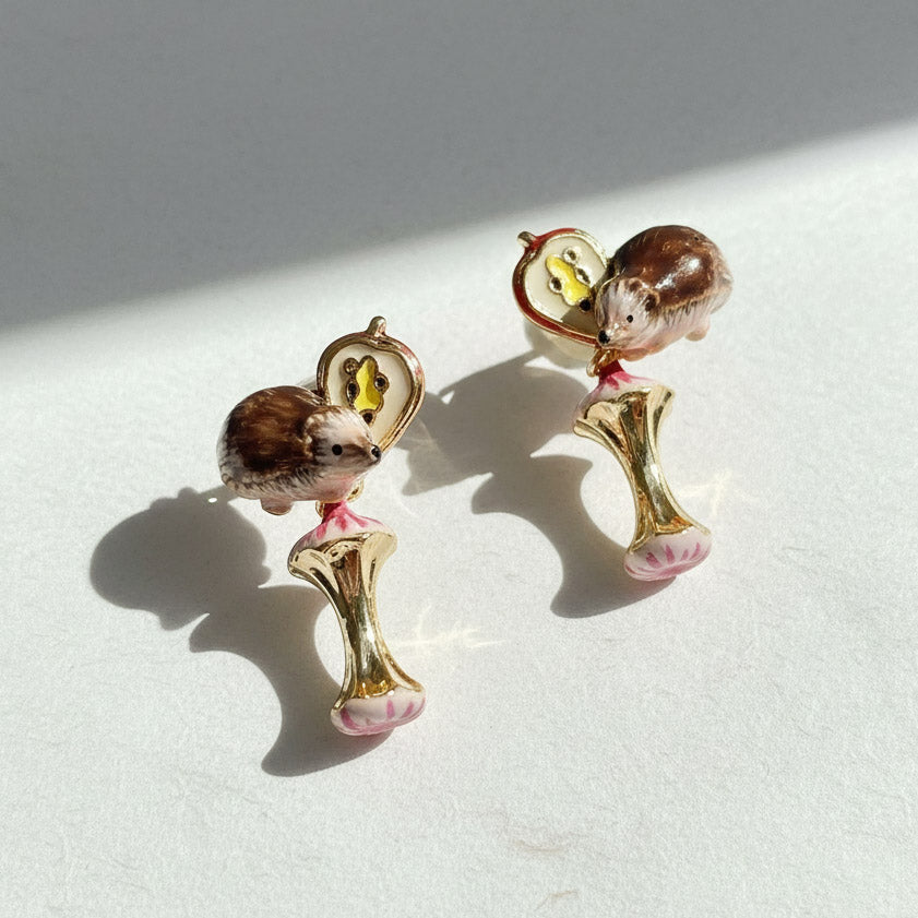 Pair of earrings with hedgehog design on a light background