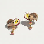 Hedgehog and apple earrings on a light background