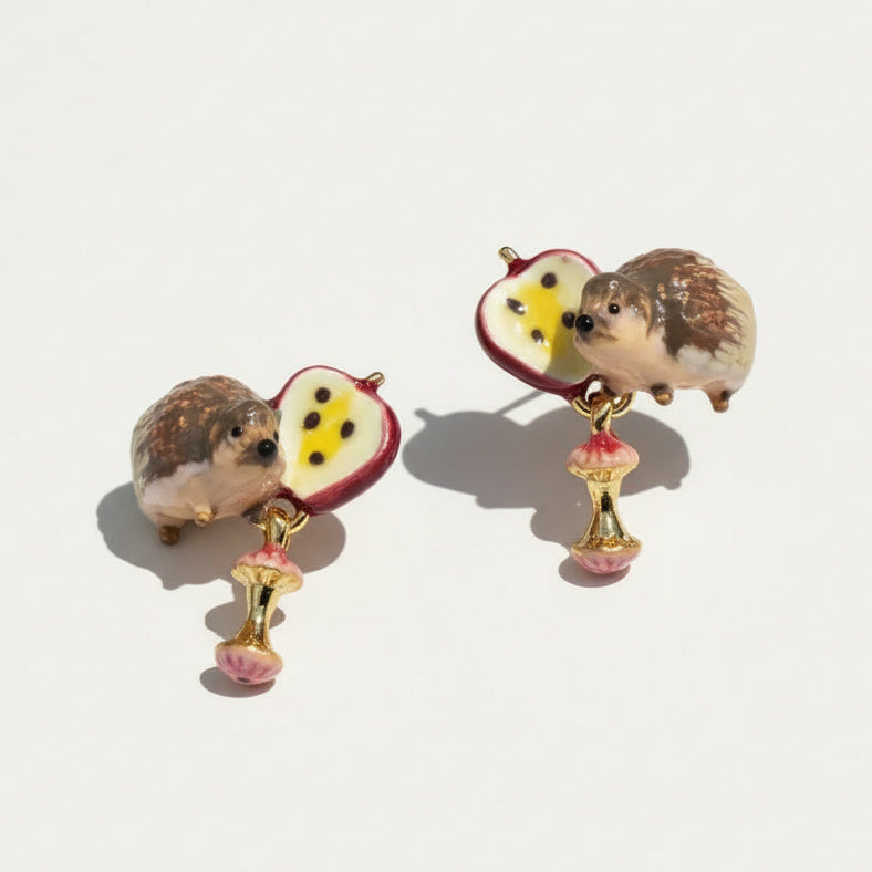 Hedgehog and apple earrings on a light background