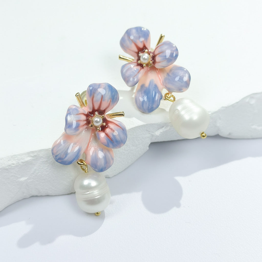 Pair of floral earrings with pearl accents on a white background