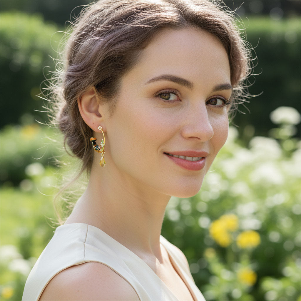 Woman wearing gold earrings with a blurred garden background