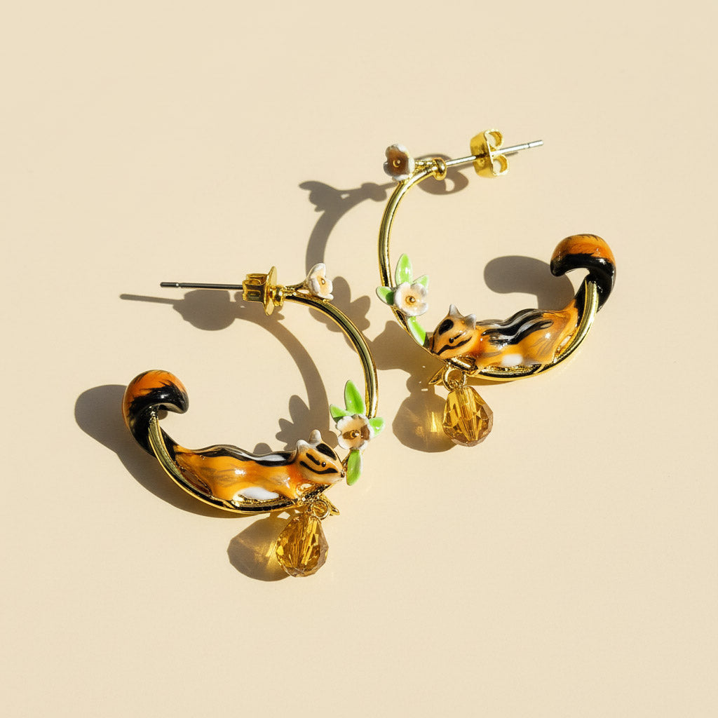 Pair of hoop earrings with chipmunk design on a beige background