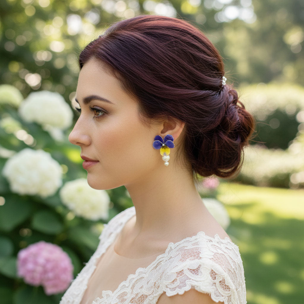 Woman with styled hair and earrings in a garden setting