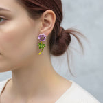 Close-up of a woman wearing a floral earring with a blurred background