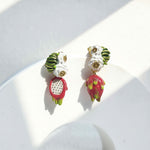 Colorful earrings with pink and green designs on a white background