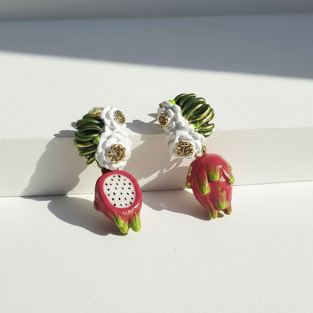Earrings resembling dragon fruit on a white surface
