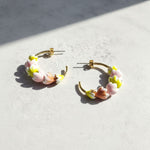 Hoop earrings with floral designs on a light surface