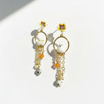 Pair of earrings with floral and chain designs on a white background