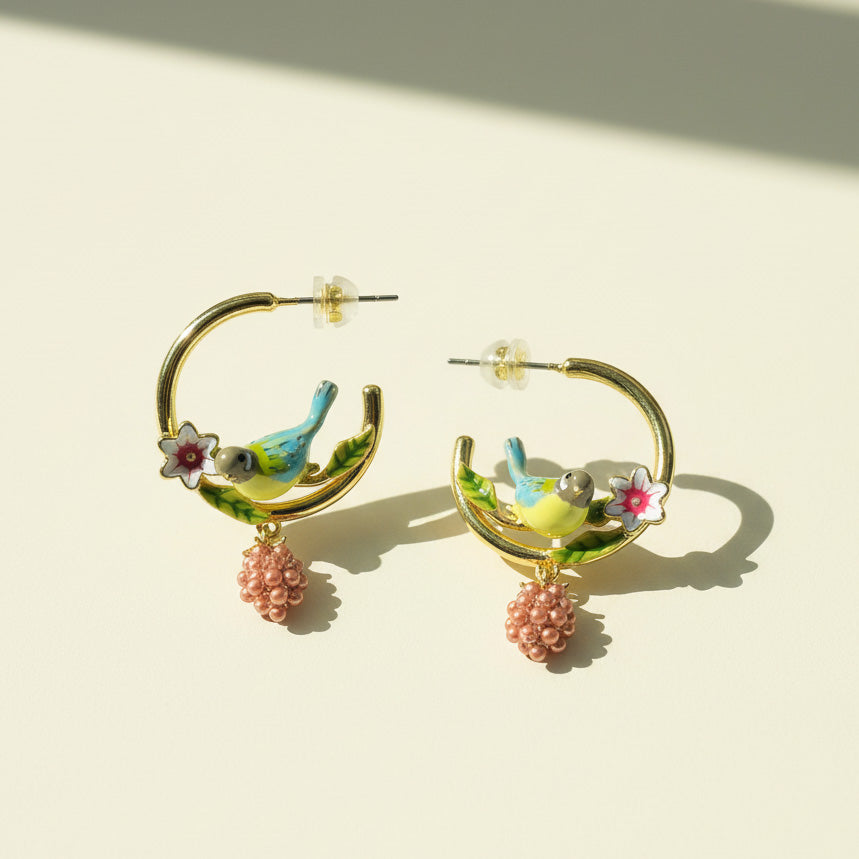 Hoop earrings with bird and flower designs on a light background