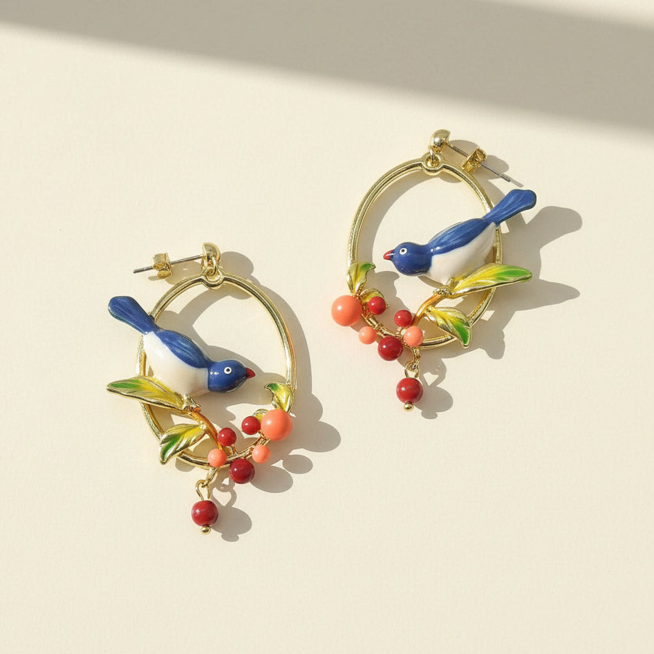 Colorful bird-shaped earrings on a beige background