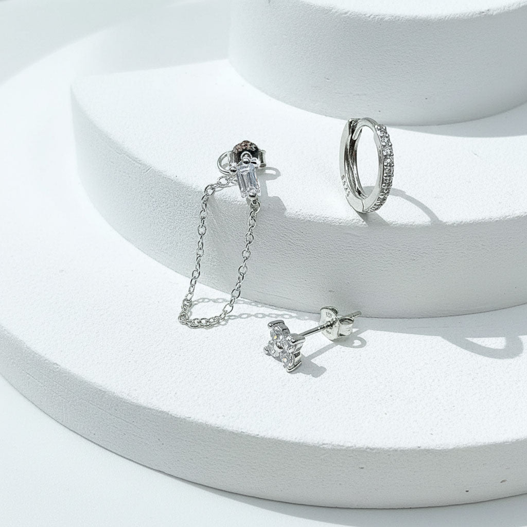 Silver earrings on a white surface